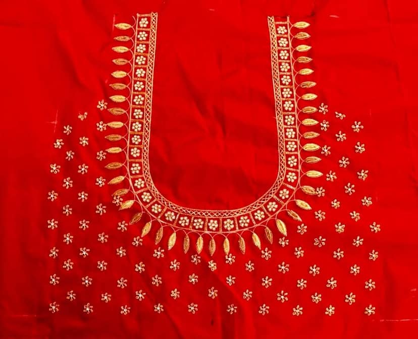 Red and gold embroidered blouse with intricate floral and leaf motifs, featuring a deep U-shaped neckline and pearl and sequin embellishments.