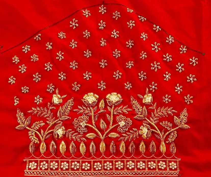 Red and gold embroidered blouse with intricate floral and leaf motifs, featuring a deep U-shaped neckline and pearl and sequin embellishments. view 3
