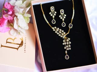 Gold Plated Kundan and Pearl Drop Earrings with Purple Stones