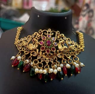 Stunning antique gold choker necklace with intricate filigree work and colorful gemstones.