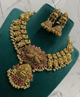 Stunning antique gold plated traditional Indian necklace set with intricate detailing and pink stones.