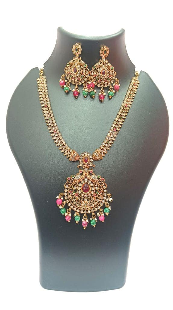 Gold-plated traditional Indian necklace set with intricate detailing and colorful stones
