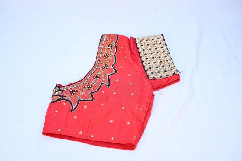 Red and gold embroidered silk blouse with intricate floral designs and zari work